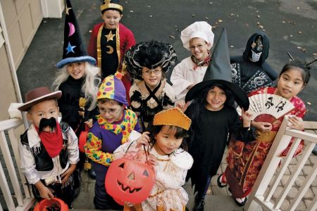 Children in Halloween costumes at front porch